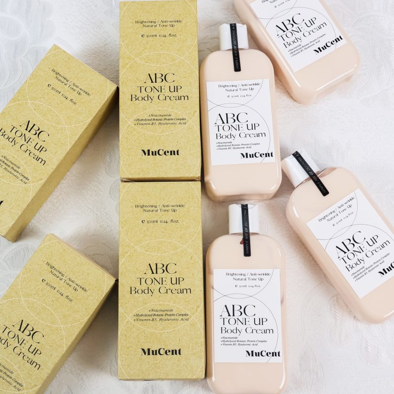 MuCent ABC Tone Up Body Cream bottles arranged at different angles for a beauty product photography shoot